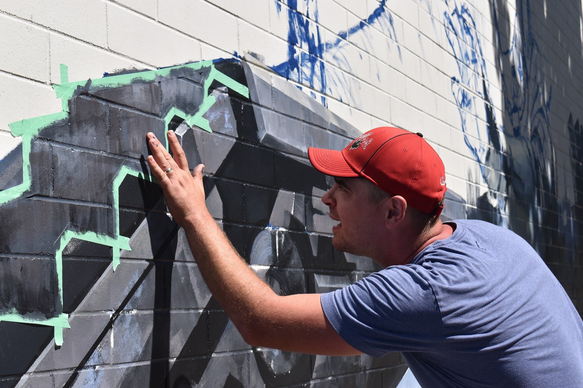 Dimitri painting his mural titled “Reflection”