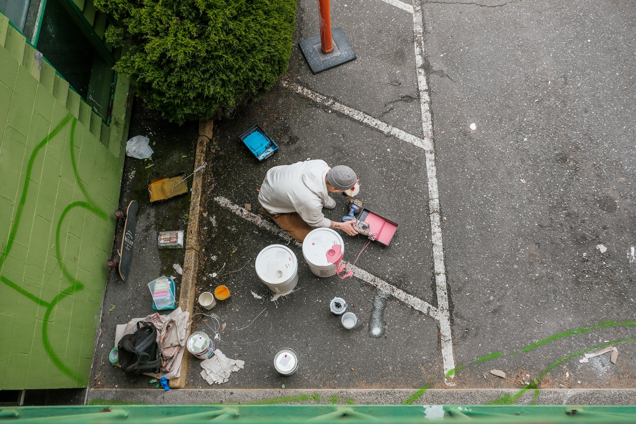 Artist, Joon Lee, in parking lot mixing paint 