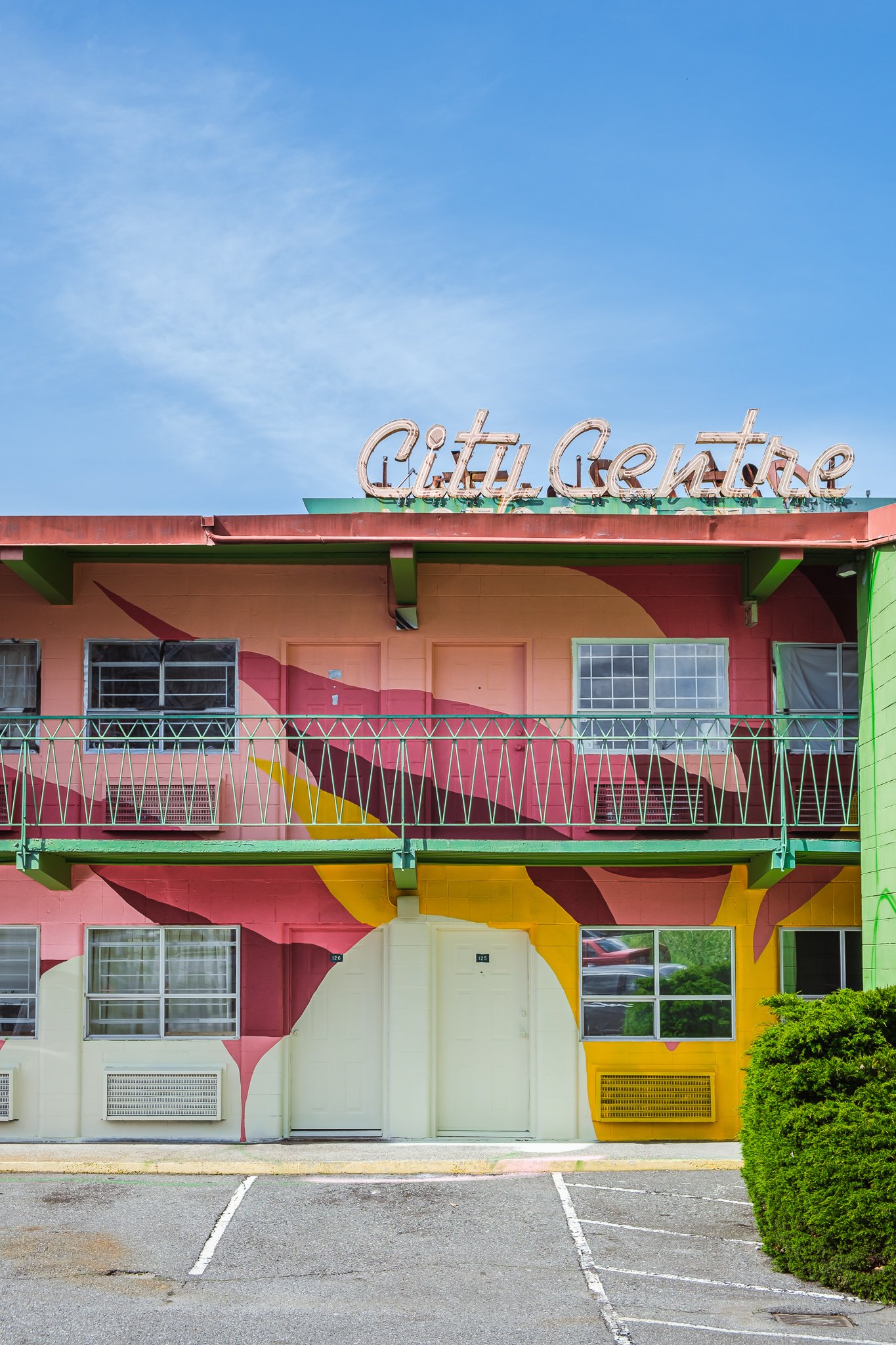 City Centre motel after painted, with neon sign, pink, reds and yellow abstract shapes 