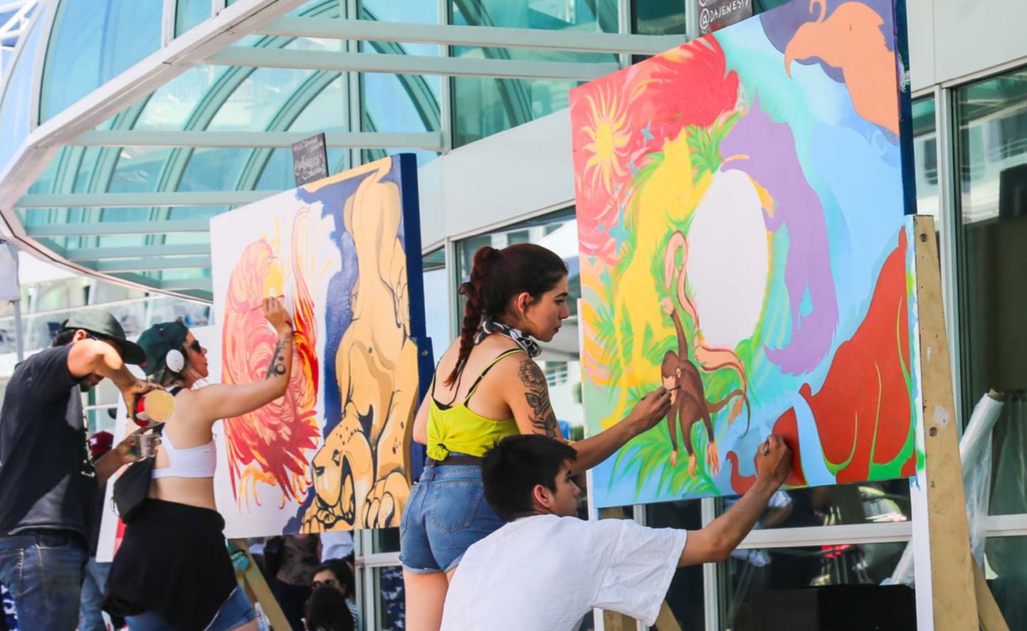 4 artists painting, two at each large easel. Colour murals with animals